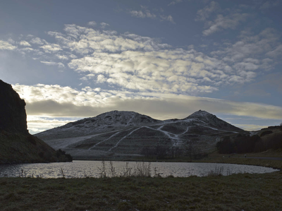 Arthur's Seat in snow with Dunsapie Loch in foreground