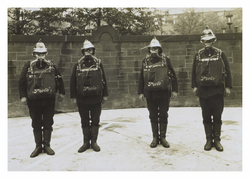 Four firemen posing in proto oxygen masks