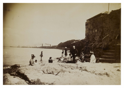 Group of people on rocks beside the shore