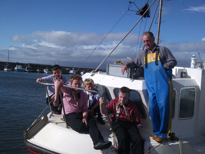 Davy Brand, fisherman, with boys from Victoria School