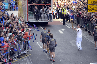 Olympic Torch Runner and security officers