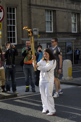Excited relay runner holding the Olympic Torch