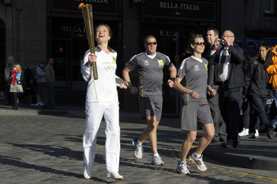 Excited Olympic Torch Relay runner passes the Tron with