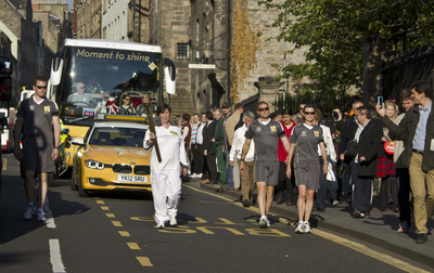 Olympic Torch Relay runner walking down the Canongate