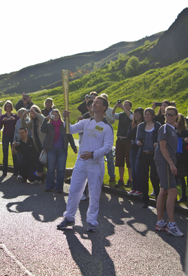 Olympic Torch Bearer standing at edge of Holyrood Park 