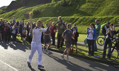 Olympic Torch Relay runner waving to crowd