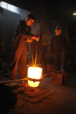 Positioning the heated crucible to receive molten iron