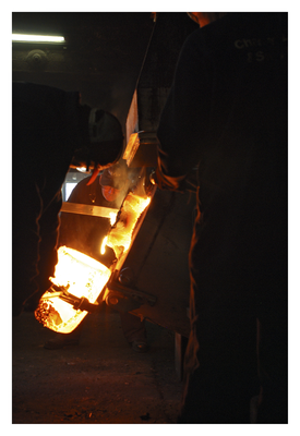 Pouring molten metal into the heated crucible