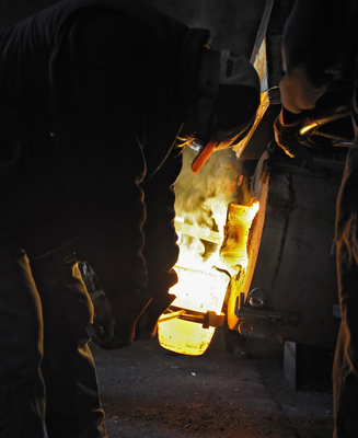 Pouring molten metal into the heated crucible