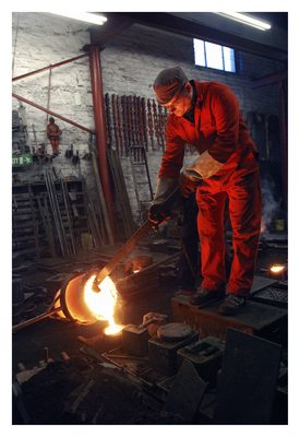 Andrew Laing helps molten iron into a mould