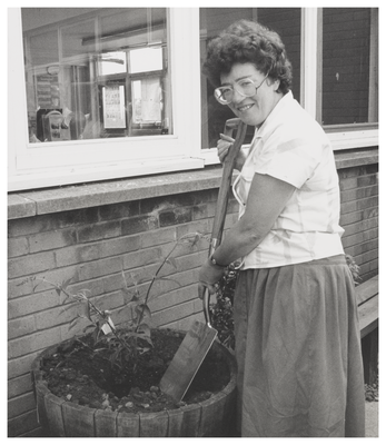 Woman standing beside a planting tub, Wester Hailes