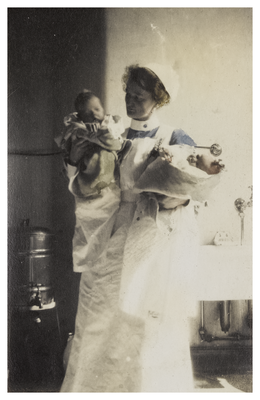 Mary Cunningham, nurse, holding two babies 