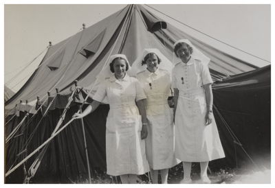 Three nurses standing outside a field hospital