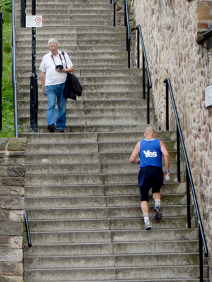 Jogger with Yes vest on running up stairs, Grassmarket