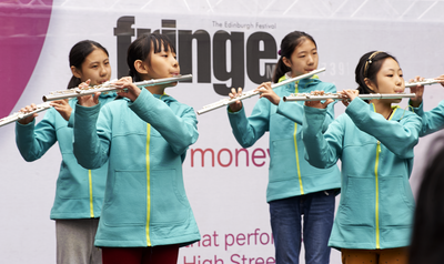 Chinese children playing flute to a Fringe crowd