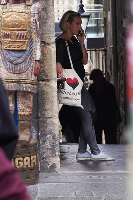 Woman on the phone with a 'I heart Edinburgh' bag