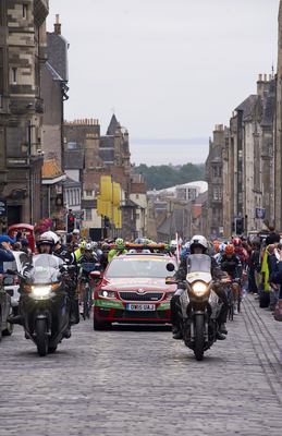 Race director's car with riders behind, High Street