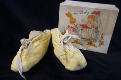 Infant's yellow silk shoes with original box, c1933